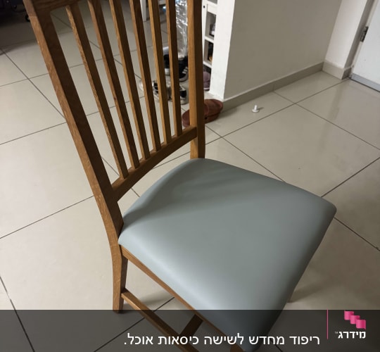 כיסא עץ עם ריפוד אפור על רצפה מרוצפת